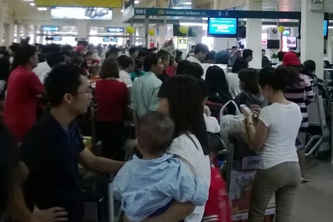 Hành khách xếp hàng làm thủ tục tại sân bay Tân Sơn Nhất. (Ảnh: Trần Tình/Vietnam+)