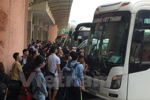 Rất đông hành khách tập trung trước xe khách để lên xe về quê. (Ảnh: Việt Hùng/Vietnam+)
