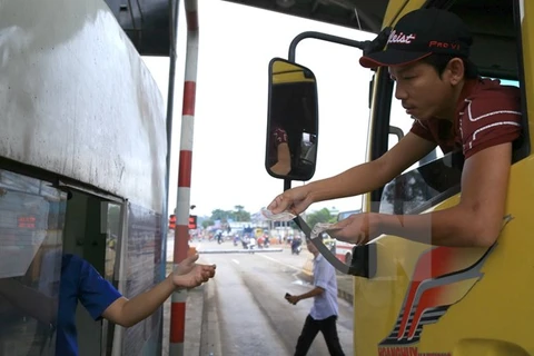 Lái xe dùng tiền mệnh giá 200-500 đồng mua vé qua trạm thu phí BOT tuyến tránh Biên Hòa gây ùn tắc kéo dài. (Ảnh: Sỹ Tuyên/TTXVN)