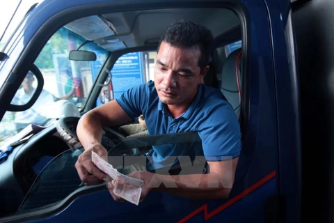 Lái xe chậm chạp trả từng đồng tiền lẻ tại trạm thu phí BOT số 1 quốc lộ 5 huyện Văn Lâm. (Ảnh: Phạm Kiên/TTXVN)