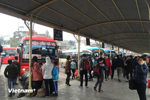 Hành khách chờ lên xe để về quê nghỉ Tết Dương lịch. (Ảnh: PV/Vietnam+)
