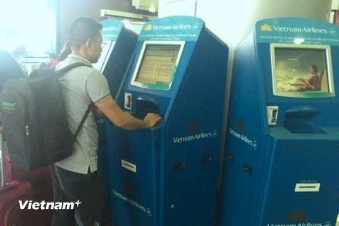 Hành khách đang làm thủ tục check-in tại kios của Vietnam Airlines. (Ảnh: Việt Hùng/Vietnam+)