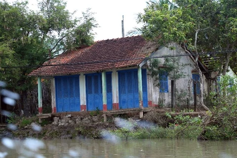 Người dân sống ven kênh Chợ Gạo nơm nớp lo sợ nhà của bị nước cuốn trôi. (Ảnh: Huy Hùng/Vietnam+)