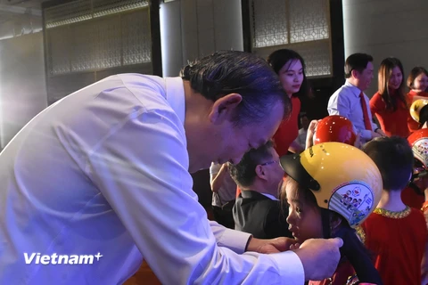 Phó Thủ tướng Chính phủ Trương Hòa Bình trao tặng mũ bảo hiểm cho học sinh lớp Một. (Ảnh: Việt Hùng/Vietnam+)