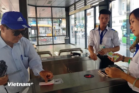 Khách sử dụng thẻ vé điện tử qua cổng kiểm soát để lên xe buýt nhanh BRT 01 Kim Mã-Yên Nghĩa. (Ảnh: Việt Hùng/Vietnam+)