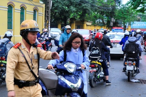 Cảnh sát giao thông sẽ xử lý những chủ xe không đội mũ bảo hiểm. (Ảnh: Võ Phương/Vietnam+)