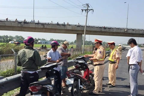 Lực lượng Cảnh sát giao thông kiểm tra, xử lý những người đi xe máy trái luật trên đường cao tốc. (Ảnh: Bùi Như Trường Giang/TTXVN)