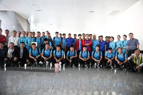 Đội tuyển Việt Nam chụp ảnh lưu niệm với nhân viên mặt đất Vietnam Airlines tại sân bay Nội Bài. (Ảnh: Hoàng Linh/TTXVN)