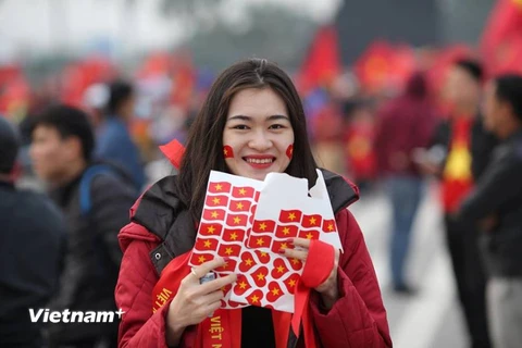 Cổ động viên nữ với băng rôn dán trên mặt sẽ tiếp lửa cho đội tuyển Việt Nam trong trận chung kết AFF Cup. (Ảnh: Minh Sơn/Vietnam+)