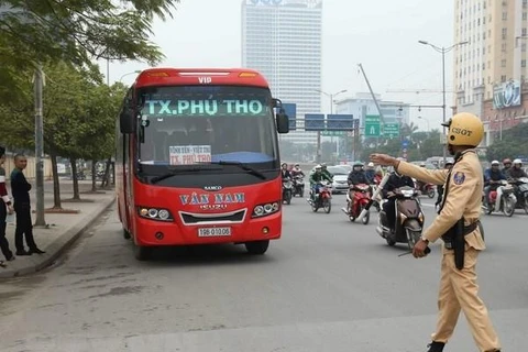 Cảnh sát giao thông xử lý trường hợp xe khách vi phạm trên đường Phạm Hùng. (Ảnh: Doãn Tấn/TTXVN)