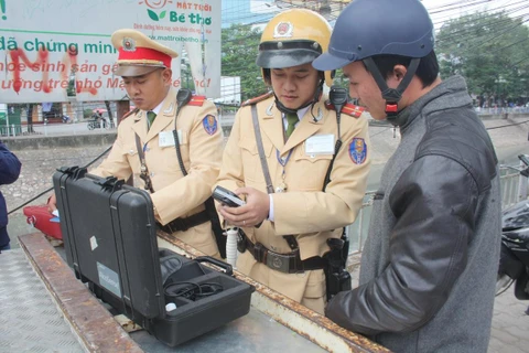 Cảnh sát giao thông tiến hành đo nồng độ cồn. (Ảnh: Việt Hùng/Vietnam+)