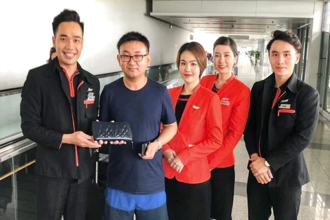 Tổ tiếp viên hãng hàng không Jetstar Pacific trao trả tài sản khách bỏ quên trên máy bay. (Ảnh: CTV/Vietnam+)