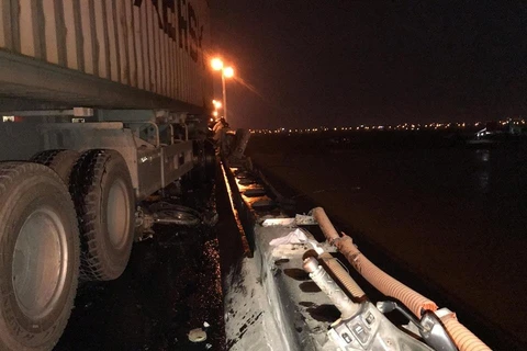 Phần lan can cầu Thanh Trì bị xe container đâm đổ xuống sông Hồng. (Ảnh: Sơn Bách/Vietnam+)