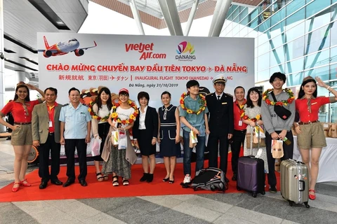 Tặng hoa cho những hành khách đầu tiên trên chuyến bay mới mở Đà Nẵng-Tokyo của hãng hàng không Vietjet. (Ảnh: CTV/Vietnam)