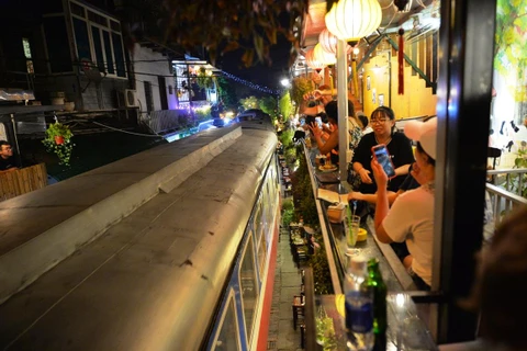 Trước khi bị đóng cửa, nhiều du khách đã đến Phố càphê đường tàu để trải nghiệm cảm giác ngồi uống nước sát với đoàn tàu chạy qua. (Ảnh: Hoàng Anh/Vietnam+)