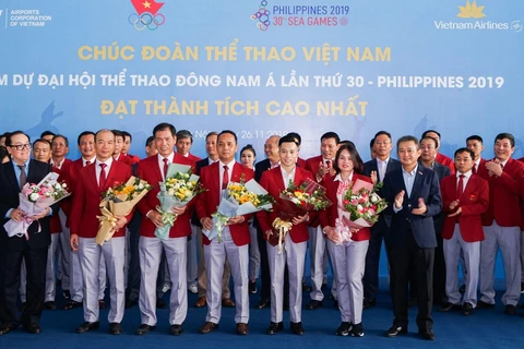 Ông Dương Trí Thành, Tổng giám đốc Vietnam Airlines (áo đen, ngoài cùng bên phải) tặng hoa và chúc mừng Đoàn thể thao Việt Nam gặt hái nhiều thành công tại SEA Games 30. (Ảnh: CTV/Vietnam+)