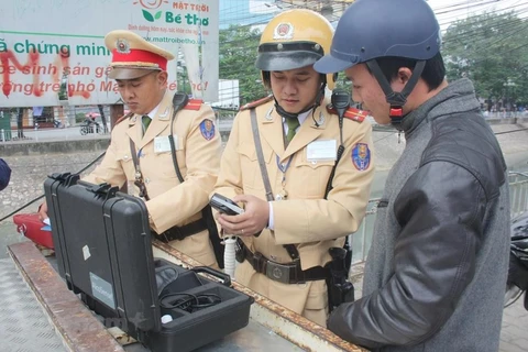 Cảnh sát giao thông tiến hành đo nồng độ cồn đối với người điều khiển phương tiện. (Ảnh: Việt Hùng/Vietnam+)