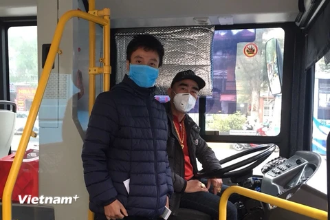 Tài xế và nhân viên phụ xe buýt tại Hà Nội đeo khẩu trang phòng chống dịch virus corona mới. (Ảnh: CTV/Vietnam+)