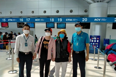 Các hành khách thể hiện tâm trạng phấn khởi khi bay trở về. (Ảnh: CTV/Vietnam+)