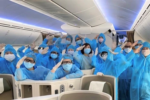 Phi hành đoàn Vietnam Airlines được trang bị đồ bảo hộ y tế đặc chủng, kính mắt, gang tay nhằm phòng chống dịch COVID-19. (Ảnh: CTV/Vietnam+)
