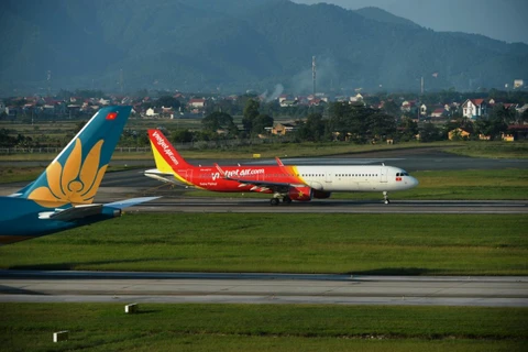 Máy bay của hãng hàng không Vietjet Air và Vietnam Airlines hạ cánh tại một sân bay. (Ảnh: Hoàng Anh/Vietnam+)