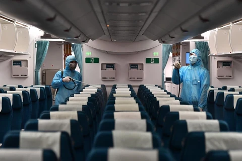 Vietnam Airlines đã thực hiện nghiêm phun khử trùng khoang khách, tập trung các vị trí hành khách tiếp xúc nhiều như ngăn hành lý, ghế ngồi… (Ảnh: CTV/Vietnam+)