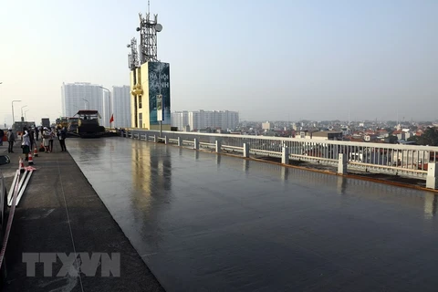 Thi công thảm bê tông Polymer trên mặt cầu Thăng Long. (Ảnh: Huy Hùng/TTXVN)