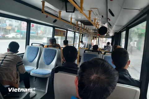 Hành khách đeo khẩu trang và được bố trí ngồi giãn cách theo đúng quy định khi đi xe buýt. (Ảnh: Việt Hùng/Vietnam+)