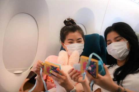 Các hành khách nữ thích thú trước món quà bất ngờ từ Vietnam Airlines nhân ngày 8/3. (Ảnh: CTV/Vietnam+)