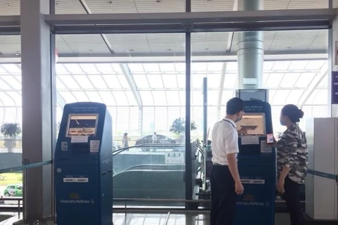 Hành khách làm thủ tục tại kiosk check-in ở sân bay. (Ảnh: CTV/Vietnam+)