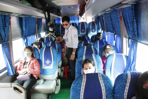 Nhân viên bến xe kiểm tra hành khách đeo khẩu trang, đảm bảo giãn cách theo đúng quy định về phòng chống dịch COVID-19. (Ảnh: Việt Hùng/Vietnam+)