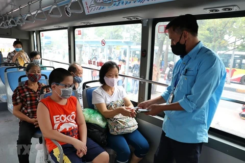 Hành khách và nhân viên xe buýt đều đeo khẩu trang. (Ảnh: Danh Lam/TTXVN)
