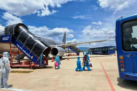 Hành khách Quảng Nam xuống sân bay Đà Nẵng và được bố trí đưa về cách ly tập trung, bảo đảm quy trình khép kín phòng chống dịch. (Ảnh: CTV/Vietnam+)