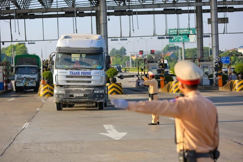 Cảnh sát giao thông dừng phương tiện vận tải hàng hóa để kiểm tra trước cửa ngõ vào địa phương. (Ảnh: Minh Sơn/Vietnam+)