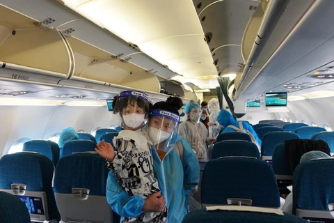 Hành khách trên chuyến bay của Vietnam Airlines đưa 200 người dân Quảng Nam từ Thành phố Hồ Chí Minh hồi hương. (Ảnh: CTV/Vietnam+)