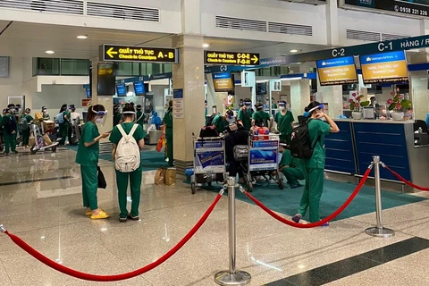 Đoàn y bác sỹ làm thủ tục tại sân bay Tân Sơn Nhất. (Ảnh: CTV/Vietnam+)
