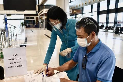 Hành khách đi máy bay làm thủ tục kê khai thông tin di chuyển nội địa để đảm bảo cho công tác phòng, chống dịch COVID-19. (Ảnh: CTV/Vietnam+)