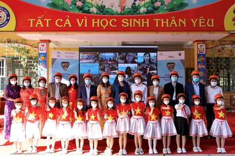 Giáo viên và học sinh tại tỉnh Thái Nguyên nhận mũ bảo hiểm từ dự án Hành trong an toàn. (Ảnh: CTV/Vietnam+)
