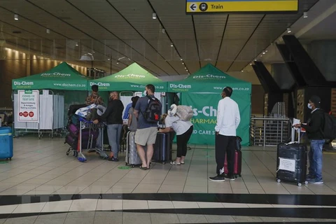 Hành khách xếp hàng chờ xét nghiệm COVID-19 tại sân bay quốc tế OR Tambo ở Johannesburg, Nam Phi. (Ảnh: AFP/TTXVN)