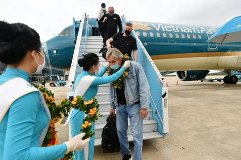 Những hành khách quốc tế trên chuyến bay của Vietnam Airlines đến Việt Nam. (Ảnh: CTV/Vietnam+)