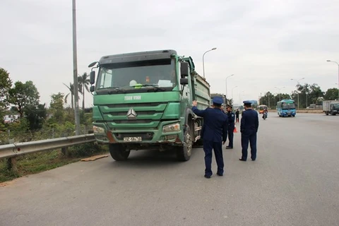 Lực lượng Thanh tra giao thông vận tải xử lý xe chở hàng quá tải trọng lưu thông trên một tuyến đường. (Ảnh: CTV/Vietnam+)