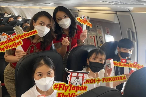 Hành khách vui vẻ, hào hứng trên chuyến bay Vietjet giữa Hà Nội và Nhật Bản. (Ảnh: CTV/Vietnam+)