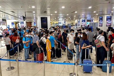 Hành khách xếp hàng làm thủ tục đi máy bay tại Cảng hàng không quốc tế Nội Bài. (Ảnh: CTV/Vietnam+)