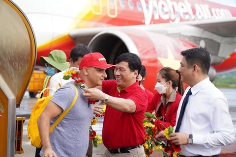 Lãnh đạo tỉnh Kiên Giang và Vietjet tặng hoa du khách trên chuyến bay từ quốc gia 1,4 tỷ dân Ấn Độ tới với Phú Quốc. (Ảnh: CTV/Vietnam+)