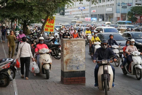 Tình trạng người điều khiển xe máy đội mũ bảo hiểm không đạt chuẩn vẫn còn phổ biến tại Việt Nam. (Ảnh: Việt Hùng/Vietnam+)
