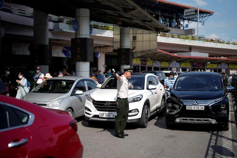 Lực lượng An ninh kiểm soát sân đỗ ôtô tăng cường điều tiết, phân luồng phương tiện tại sân bay. (Ảnh: CTV/Vietnam+)