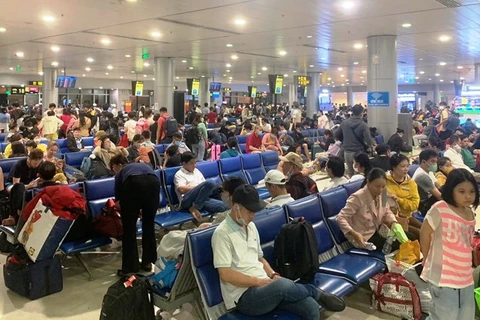 Hành khách ngồi chờ tại khu vực chờ lên máy bay tại Cảng hàng không quốc tế Tân Sơn Nhất. (Ảnh: CTV/Vietnam+)
