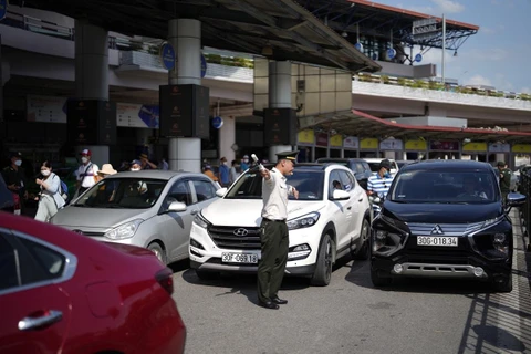 Lực lượng an ninh sân đỗ ôtô tăng cường điều tiết phương tiện ra, vào Cảng hàng không quốc tế Nội Bài. (Ảnh: CTV/Vietnam+)