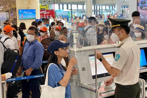 Hành khách làm thủ tục kiểm tra giấy tờ trước khi vào soi chiếu để đi máy bay. (Ảnh: PV/Vietnam+)