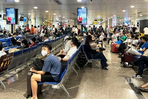 Hành khách ngồi chờ lên máy bay tại Cảng hàng không quốc tế Tân Sơn Nhất. (Ảnh: Việt Hùng/Vietnam+)
